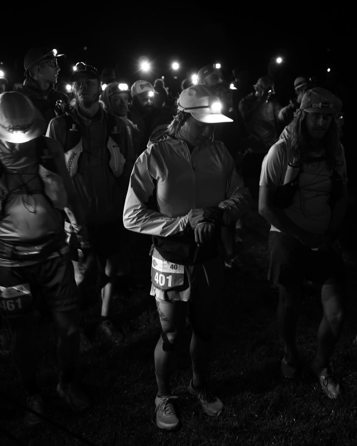 Trail runners with headlamps at a nighttime start